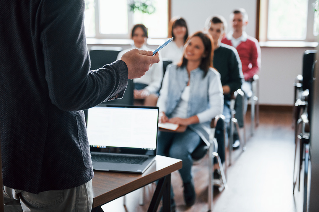 Teacher delivering class to adult students in classroom